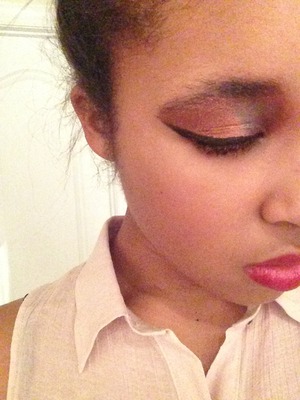 Bold black winged eyeliner pared with bronze-y shadow and a bold pink lip.
