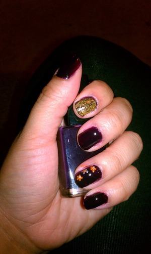 I painted the nails maroon, then added loose gold glitter, and lastly used a dotting tool and added flowers 