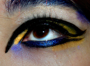 Cut crease with white and gold, with gold on the inner corner and under the lower waterline, also with a midnight blue eyeliner for the lower waterline underlined with liquid black liner, brows are lined with blue pencil
