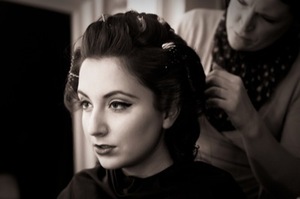 A 1940s photoshoot. Basic sleek eyeliner, highlighted eyebrow, red lips. 
Rollers in hair, very 40s/50s.