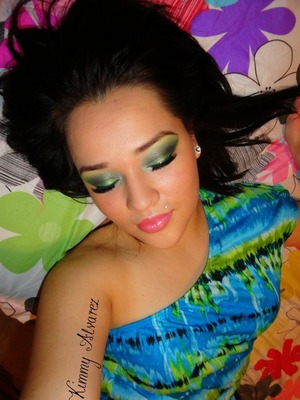 dramatic/metallic green tones,golden highlight, golden glitter,heavy falsies and strong eyebrows.