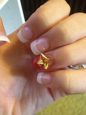 French tip Acrylics , my ring finger is rounded and painted red with gold spikes .