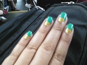 Reverse French tip in a green teal and gold 