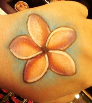Plumeria flower on my hand done in all eye shadow and makeup medium.