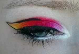 Prime with white. Use bright pink over half of the lid, then blend red, wing with orange and yellow. Bottom fades with white, gray, and black on waterline. Highlight with white and use excess under lower lash line. Outline wing with black liquid.

-Shany Cosmetics