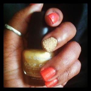 A nice manicure done with gold microbeads 