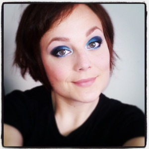 A sky-blue, shimmering smokey eye with neutral lips.