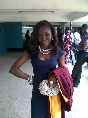 Long curly hair, blue smoky eyes, nude lips and a tinge of blush. Navy blue dress with cream neck beads.