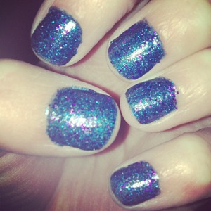 Blue nail polish with blue and purple glitter. 