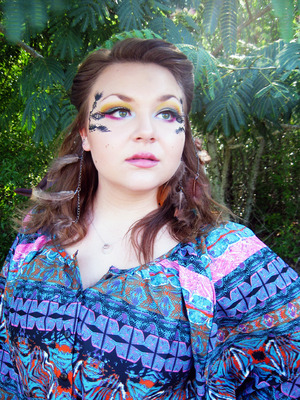 For this look, I used a variety of eyeshadows from multiple palettes and individual shadows from quite a few different companies, some high end, some low end. My foundation is Make Up For Ever's Mat Velvet in Natural Beige (40) and I made the tribal designs using Urban Decay's 24/7 Liner, the black one. My lashes are just some cheap Halloween lashes I've had for the longest time but never used. Silly me. :)