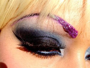 a purple glitter brow look, with a blue smokey eye
