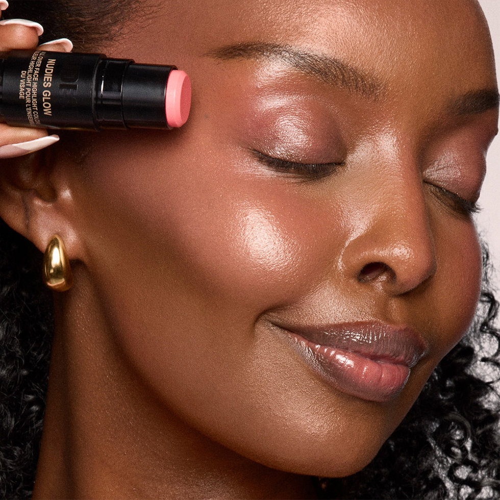 Nudestix model wearing the Nudies Glow Highlighter Stick in I Dew