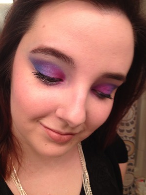 Blue, purple, and pink on the lid. Light dust over glitter over top. Nude lip. Pink cheeks. 
