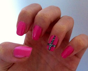 Pink nails with a black cross on the ring finger. Added some silver glitter.