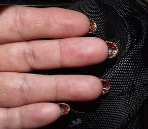 my red nails (100percent real) are under painted with a metallic black and added red dots the edge of the nail is gold glitter!!