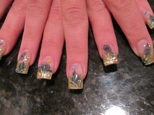  My friend had some event to go to.. she wanted glam with a twist. So, I decided to do a metallic gold acrylic, with gold glitter acrylic for the tip, and incorporated some peacock feathers with a dab of bling! ;)