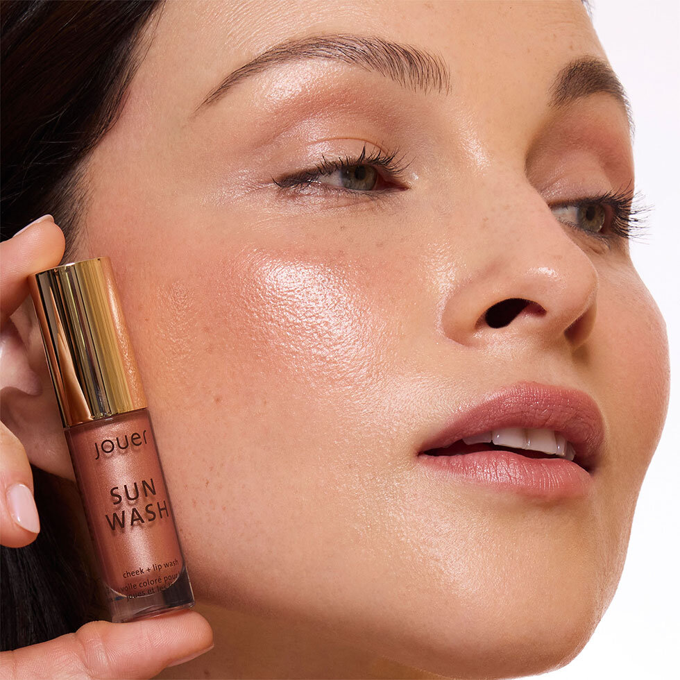 Jouer Cosmetics model wearing the Sun Wash Liquid Blush in Peché Éclat
