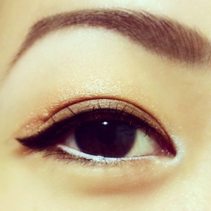 Winged eyeliner on an orange to brown gradient eyeshadow.