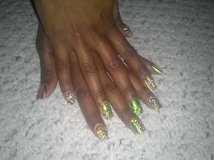 purple, green, and yellow nail polish with green and yellow stones 