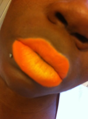 Orange eyeshadow with a golden yellow shadow pressed in the middle giving it a neon look. 