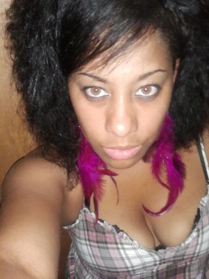 teased naturally curly hair.....swooped bangs across forehead.... and add pink fusia feather earrings to make it pop
