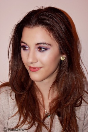 Shimmery peach shadow on the lids and purple eyeliner in a wing 