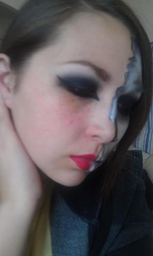 One side is a black smokey eye with red lip and the other half is a skull!
