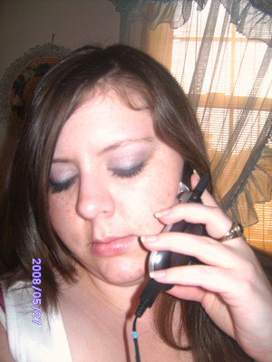putting on make up and talking to someone on the cell 