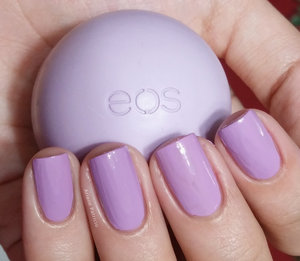 I'm holding an eos smooth sphere in the flavor Passion Fruit and this is also a swatch of The Face Shop nail polish in the shade PP401