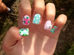 Arcylic flowered nail art design with a pearl bow 