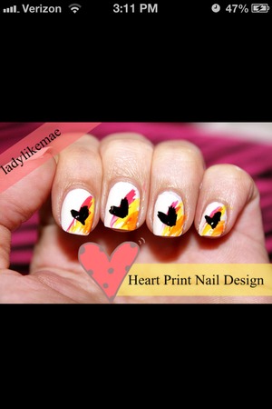White nails with black hearts with a splashes of colors diagnol of the nail