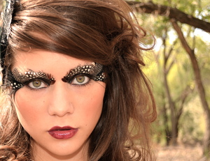 Spotted owl inspiered look. I glued feathers along her brow bone and filled in her lid with black cream shadow. 