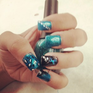 Acrylic nails, using turqouise and black nail polish, cheetah print and glitter