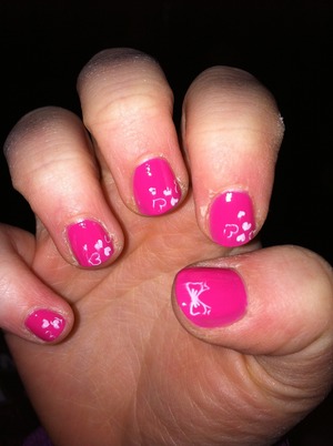 Cute pink nails with hearts and bow stamps.