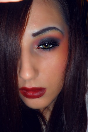 Mix of black and purple on the lid with an orange crease blended out with yellow. Lips came out more red on camera.