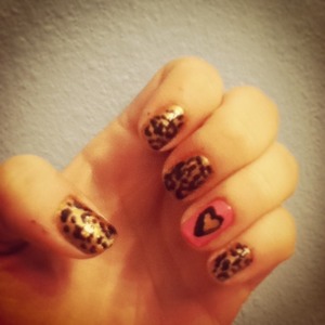I started by painting my ring fingers pink and the rest of my nails gold. Then I added random large bronze dots to the gold nails using a dotting tool. I created a gold heart on my ring finger by making a v with a large brush and rounding out the edges. I created the black outline with a smaller brush. I finished off the leopard print with a small dotting tool and creating 4-5 small black dots around each larger bronze dot. To finish off, I put a top coat over all the nails.  