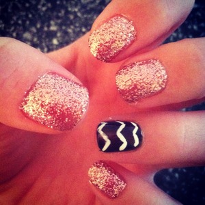 Pink sparkly nails with a black and white zig zag ring finger 