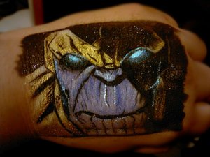 An image of Marvel's Thanos (comic book version) on my hand done entirely out of eye shadows and liquid medium.