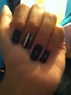 Black nails with a black and gold striped nail , free handed 