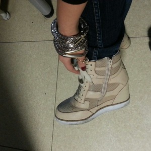 wedged sneakers with dark jeans and some jewlery 